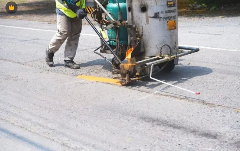UniGulf Traffic crew applying hot thermoplastic road marking with a line marking machine in Doha, Qatar