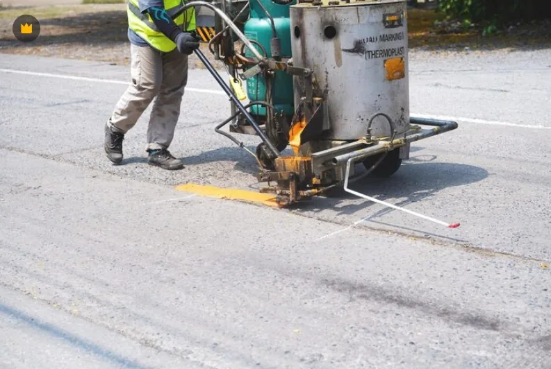 UniGulf Traffic crew applying hot thermoplastic road marking with a line marking machine in Doha, Qatar